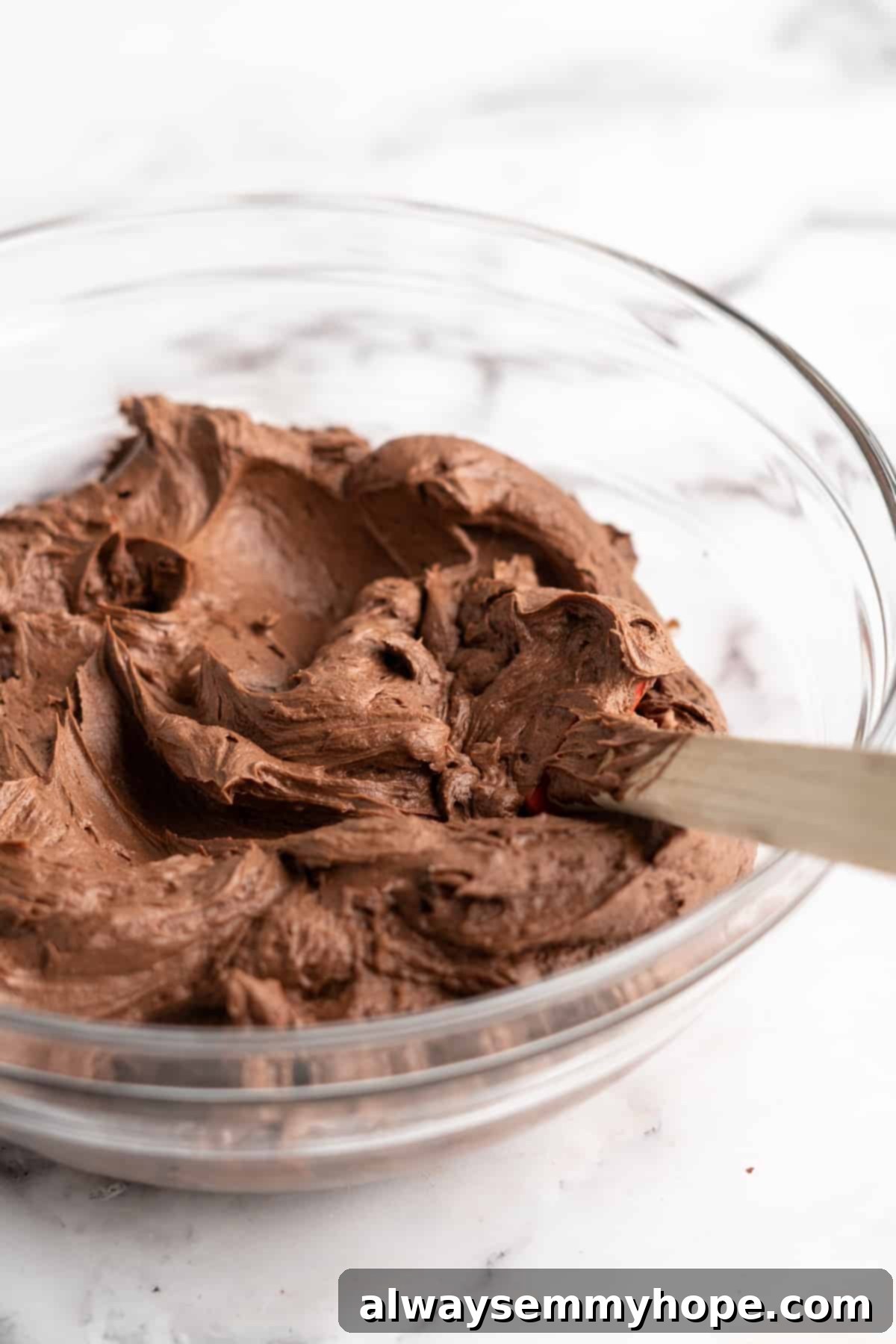 This vegan chocolate cake recipe is the best you'll ever try and the easiest too! Make it yourself and find out why it's a reader favorite. Vegan chocolate frosting in glass mixing bowl.