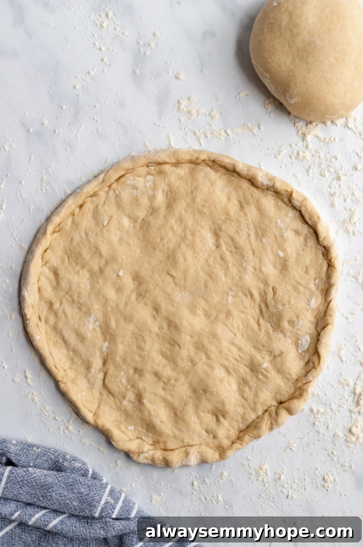 Freshly rolled out pizza dough, shaped into a perfect circle with a raised crust edge, ready for toppings.