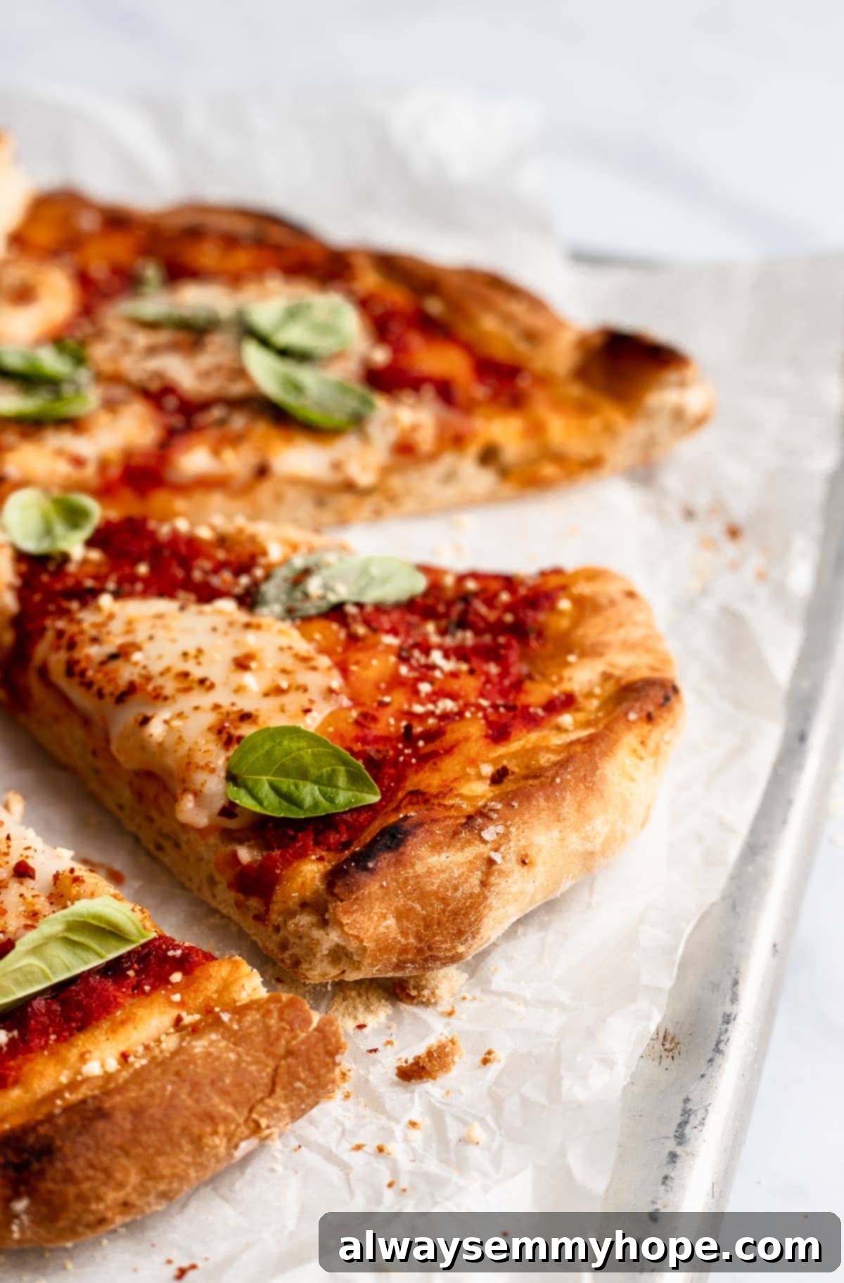 side angle shot of vegan pizza with one slice pulled out slightly, showcasing the crispy crust and melted cheese