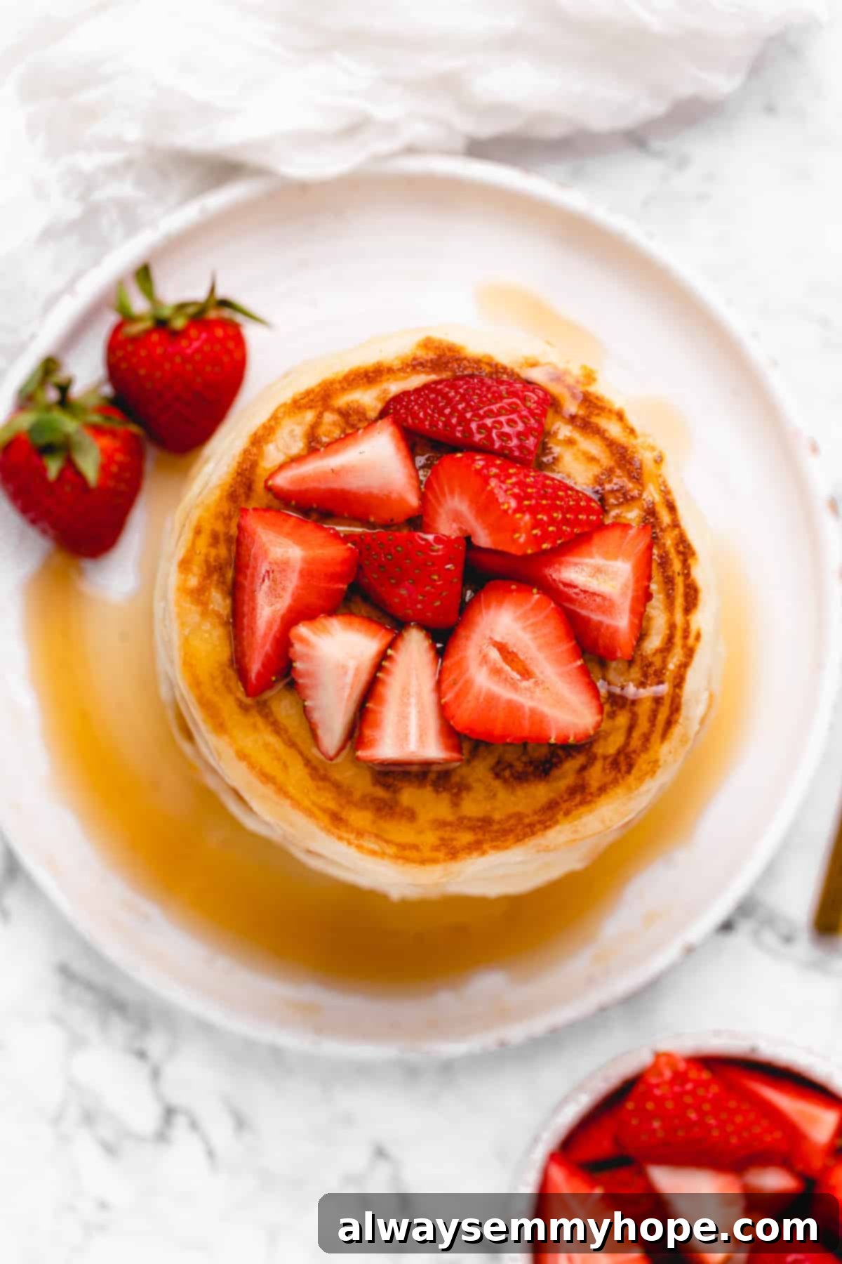 Chopped strawberries on a stack of pancakes.