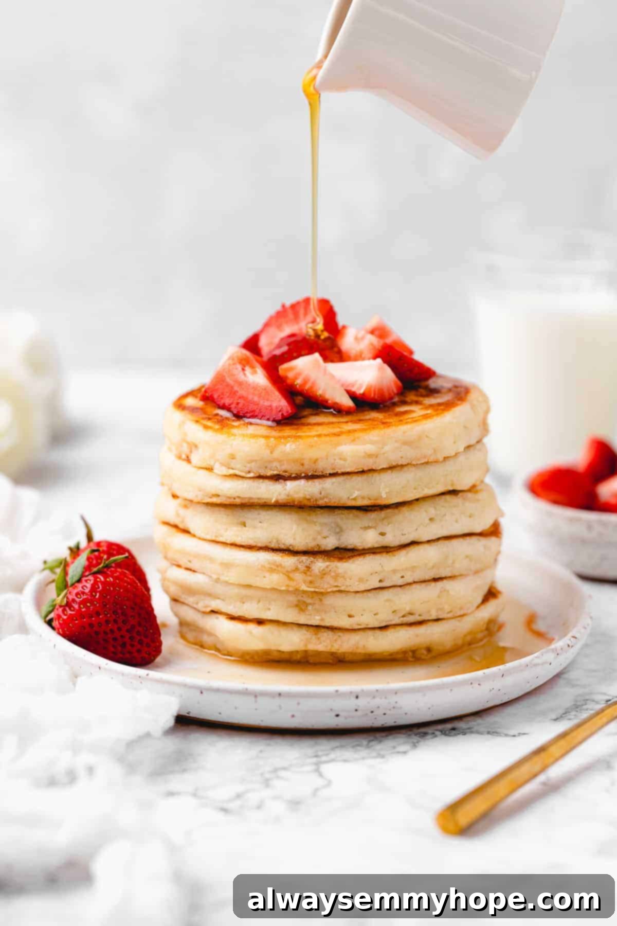 Stack of pancakes topped with strawberries.