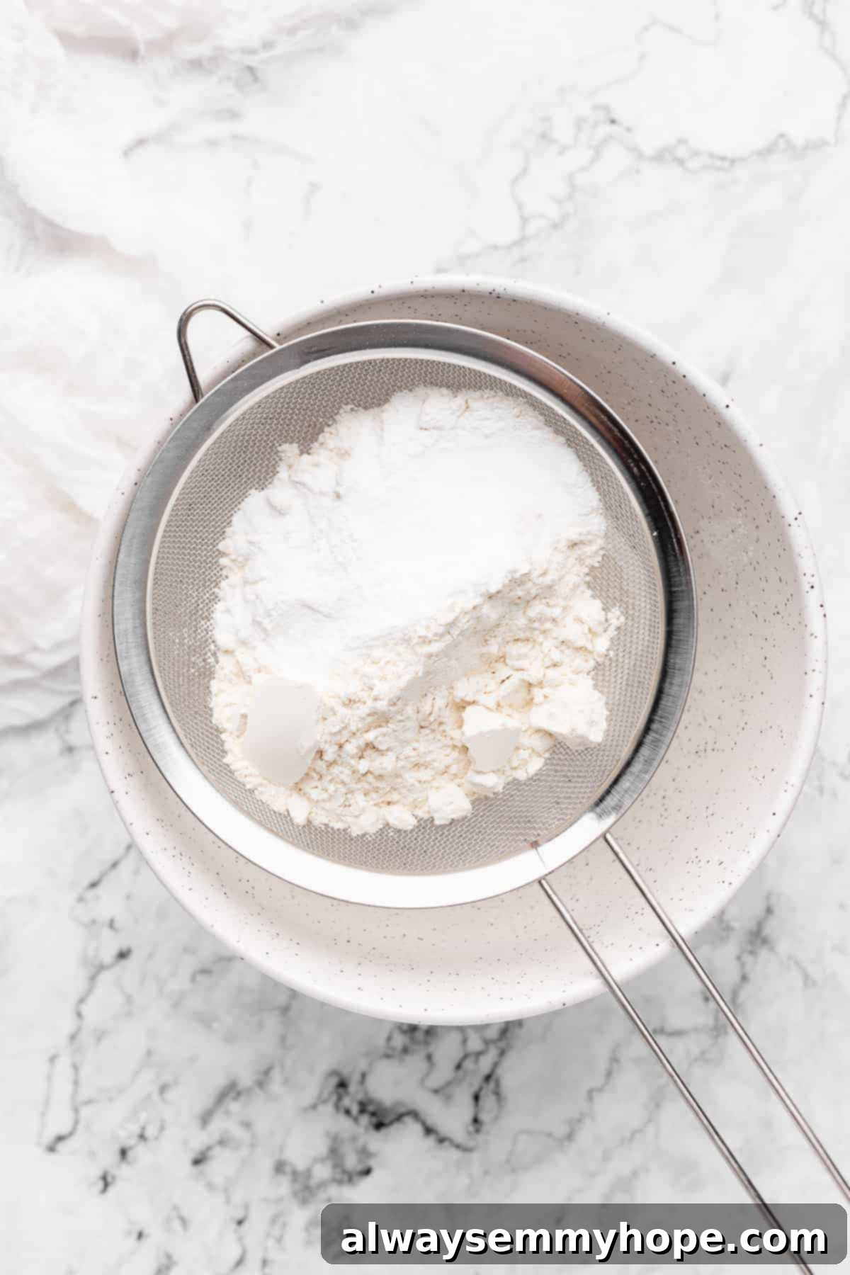 Flour being sifted into a bowl.