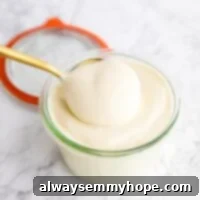 Vegan mayo being scooped out of a jar.