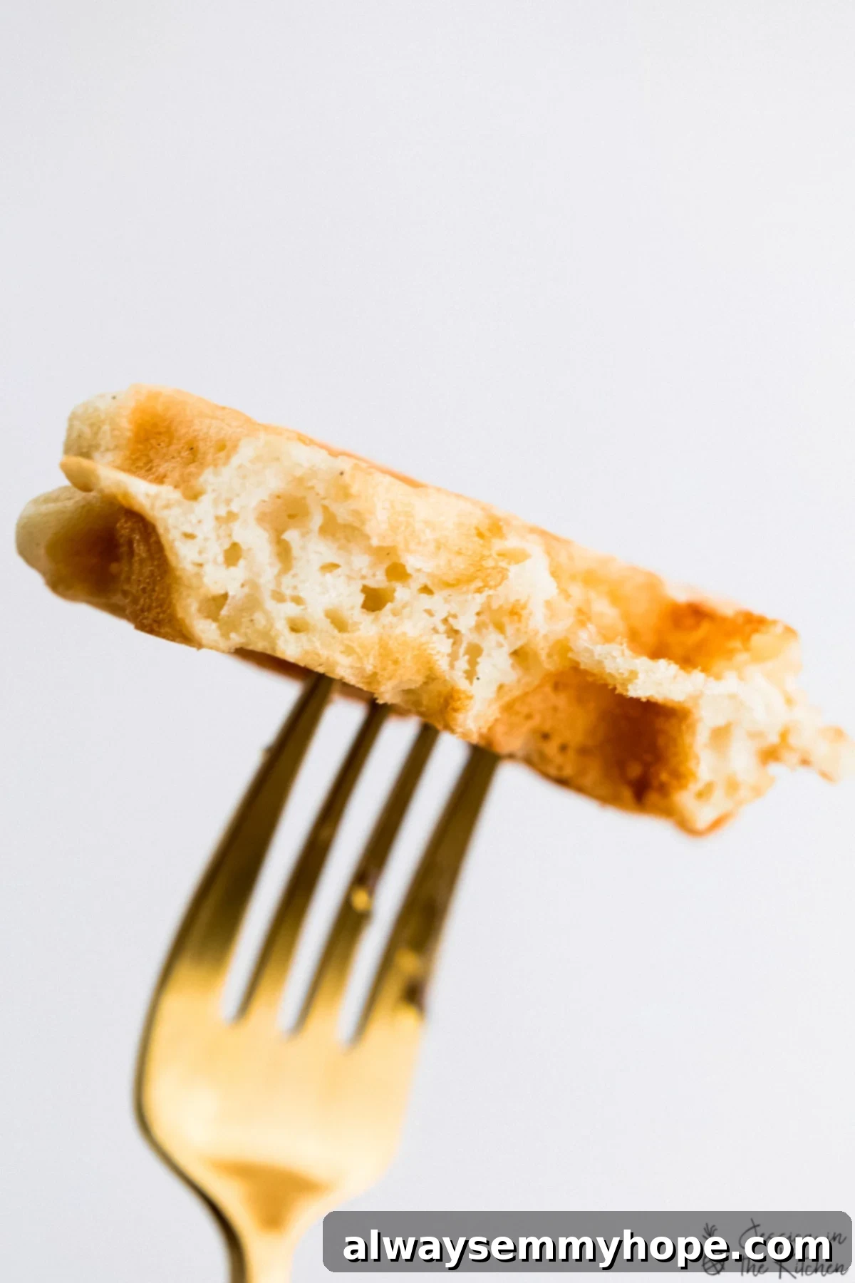 Irresistibly Fluffy Crispy Vegan Waffles 4 Close-up of a bite of vegan waffle on a fork, showing its fluffy interior