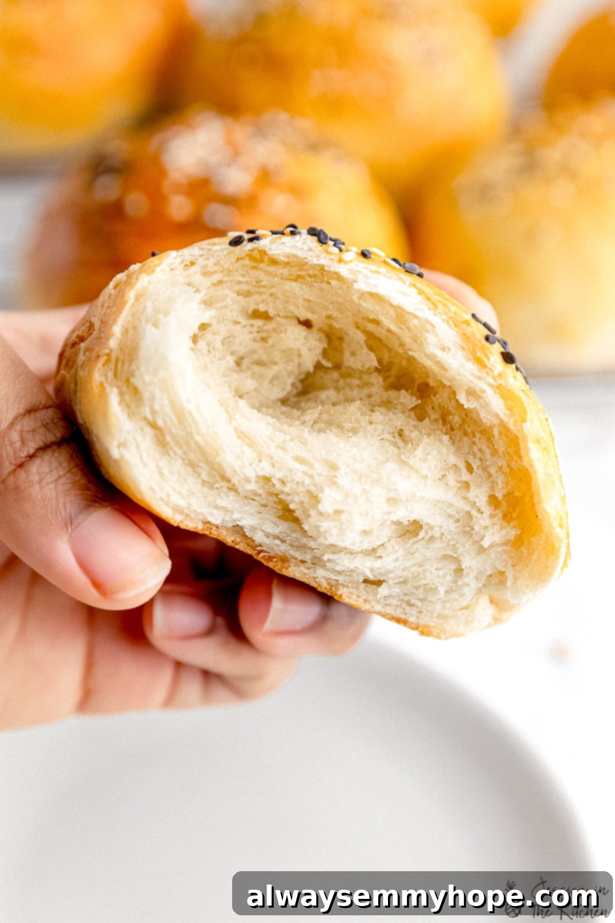 Pillowy Vegan Burger Buns 6 A vegan burger bun torn in half, revealing its soft, airy, and fluffy interior.