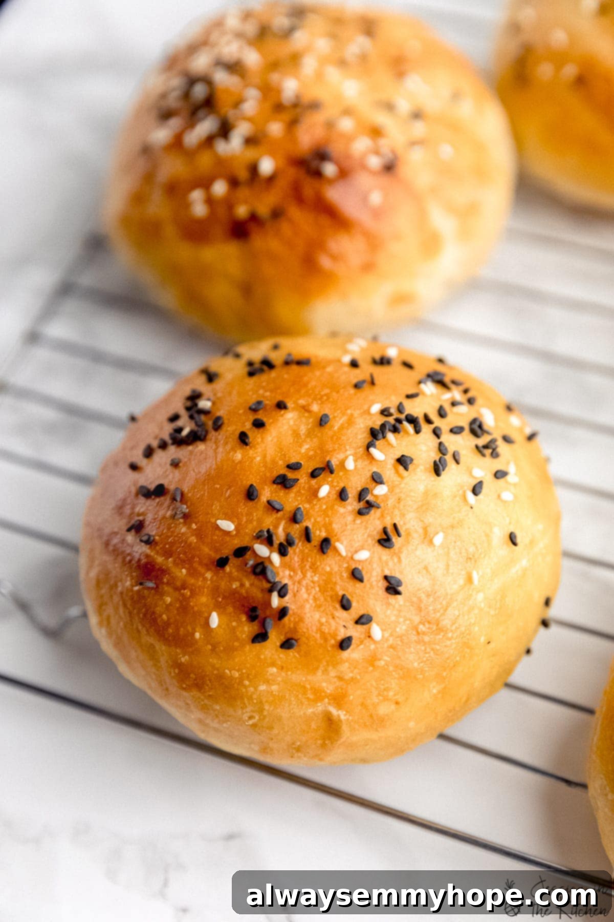Pillowy Vegan Burger Buns 8 Freshly baked vegan burger buns cooling on a wire rack.