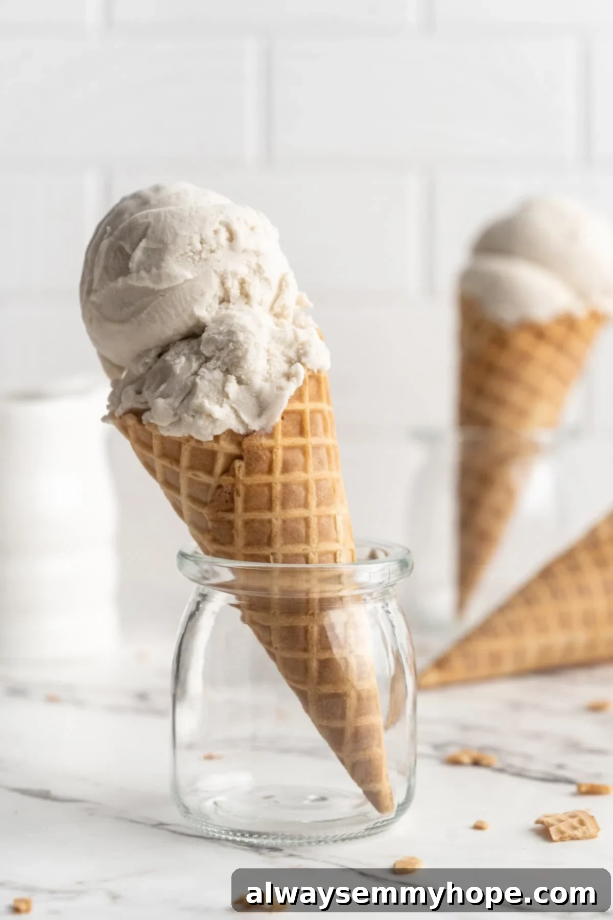 Cover this homemade vegan ice cream very tightly to prevent ice particles from forming. It will keep fresh in the freezer for up to 2 weeks. Overhead view of a single scoop of vanilla vegan ice cream in a cone, artfully placed in a glass jar