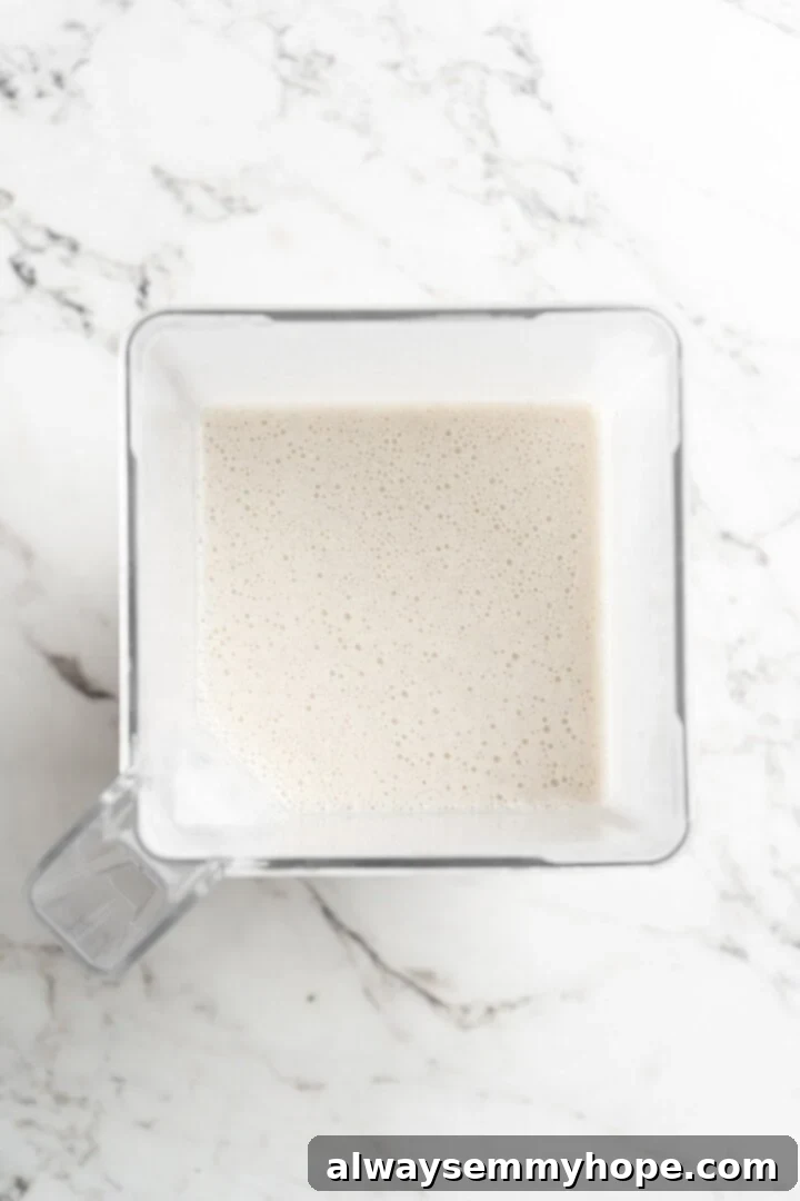 Cover this homemade vegan ice cream very tightly to prevent ice particles from forming. It will keep fresh in the freezer for up to 2 weeks. Overhead view of the creamy vegan ice cream mixture smoothly blending in a high-speed blender