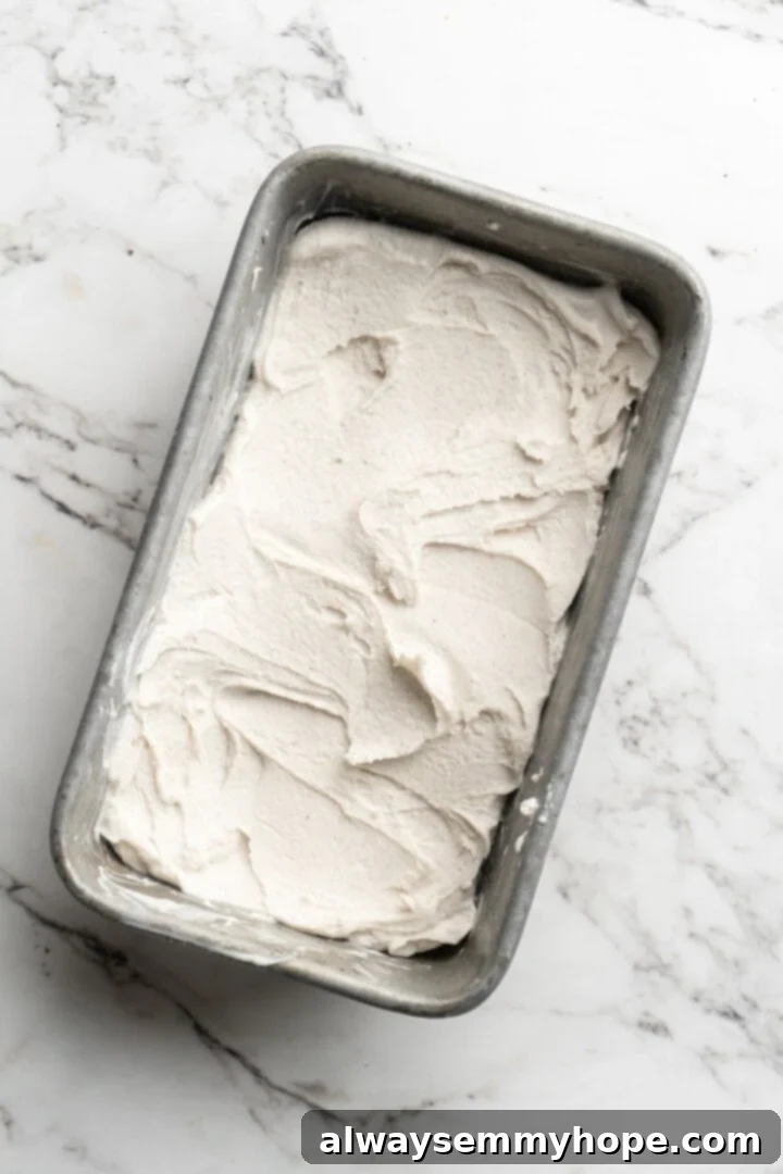 Cover this homemade vegan ice cream very tightly to prevent ice particles from forming. It will keep fresh in the freezer for up to 2 weeks. Overhead view of freshly churned, soft-serve consistency vegan ice cream transferred into a loaf pan for final freezing