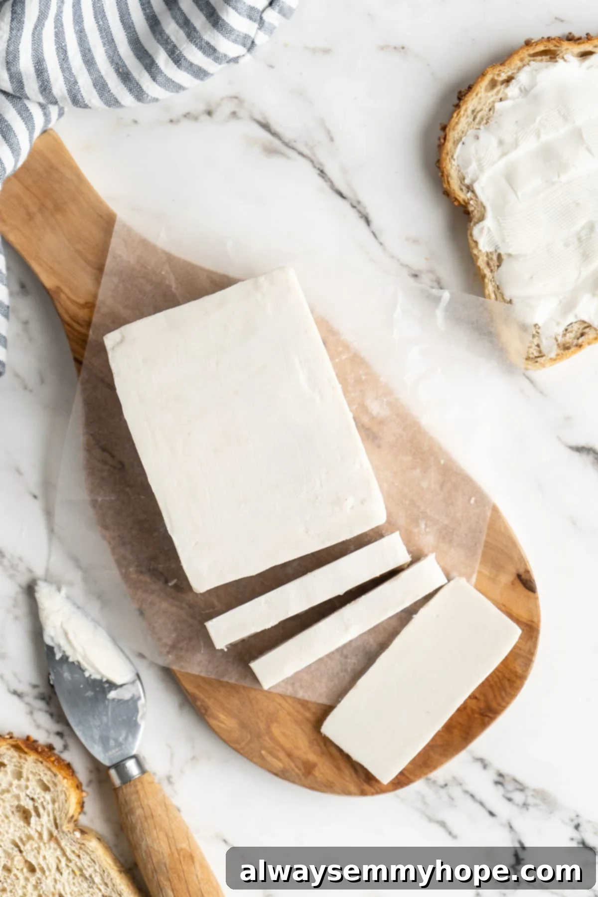 Close-up overhead view of perfectly sliced golden homemade vegan butter on a cutting board, ready to be served.