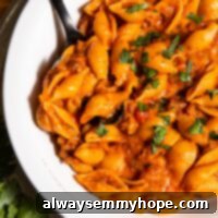 Bowl of cheesy vegan taco pasta with spoon