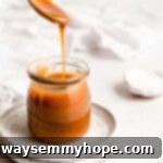 A clear glass jar filled with rich, homemade vegan caramel sauce, showcasing its luscious golden hue and smooth texture.