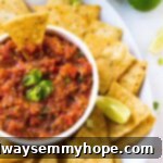 A perfect top-down shot of vibrant restaurant-style blender salsa in a white ramekin, surrounded by crunchy tortilla chips.
