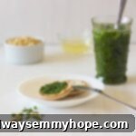 Crispy crackers topped with bright green parsley pesto, garnished with fresh herbs, ready for a delicious snack or appetizer.