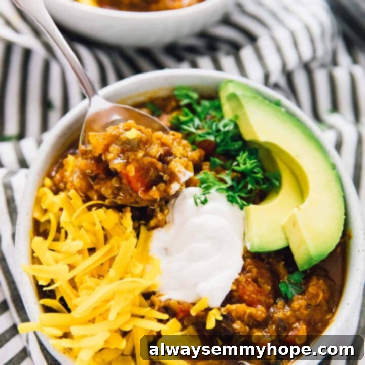 A bowl of Slow Cooker Pumpkin Quinoa Chili with a spoon.