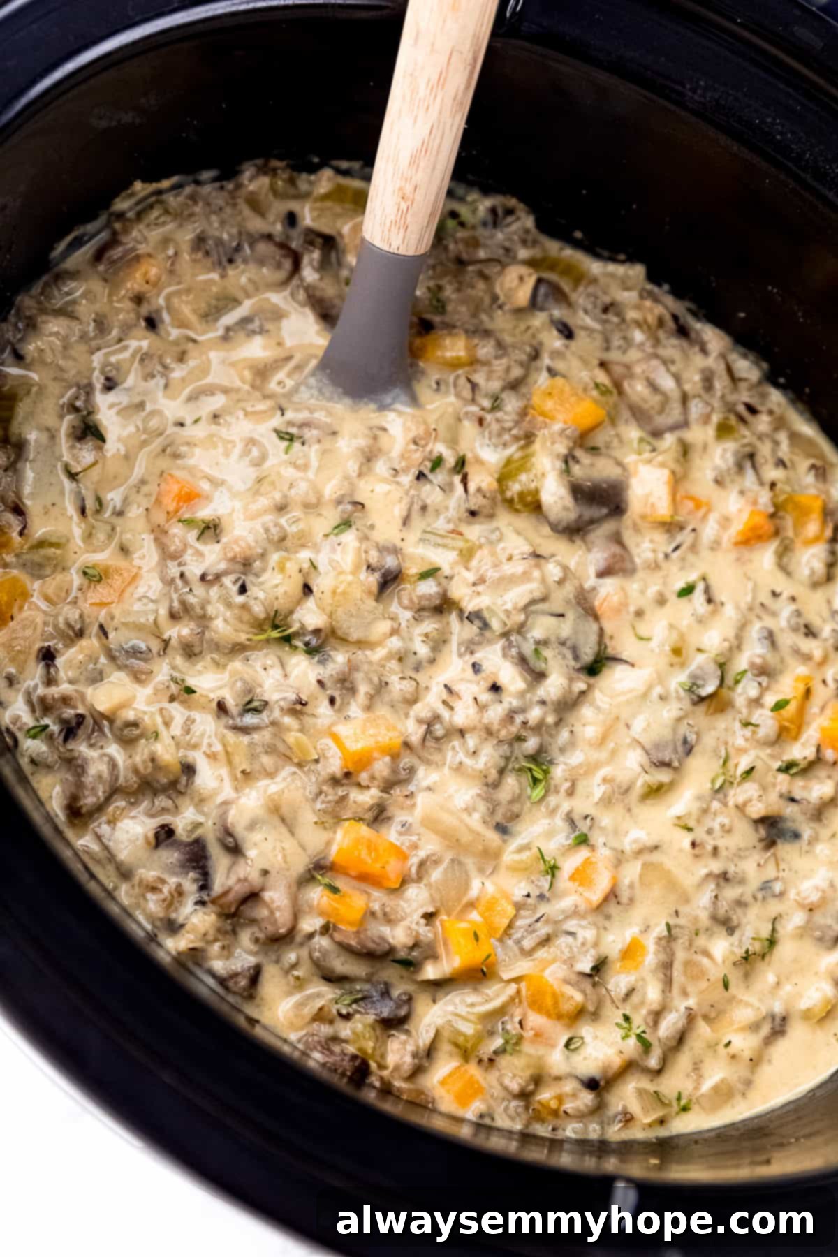 Soup in the slow cooker with ladle in it, showcasing its creamy texture and hearty ingredients.