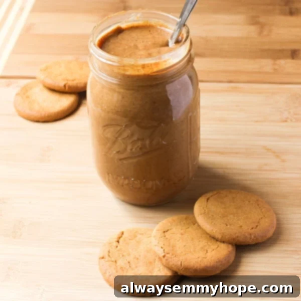 Cookie butter in a glass with cookies around it. 