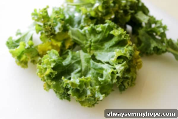 Fresh curly kale leaves on a pristine white surface, ready for smoothie preparation