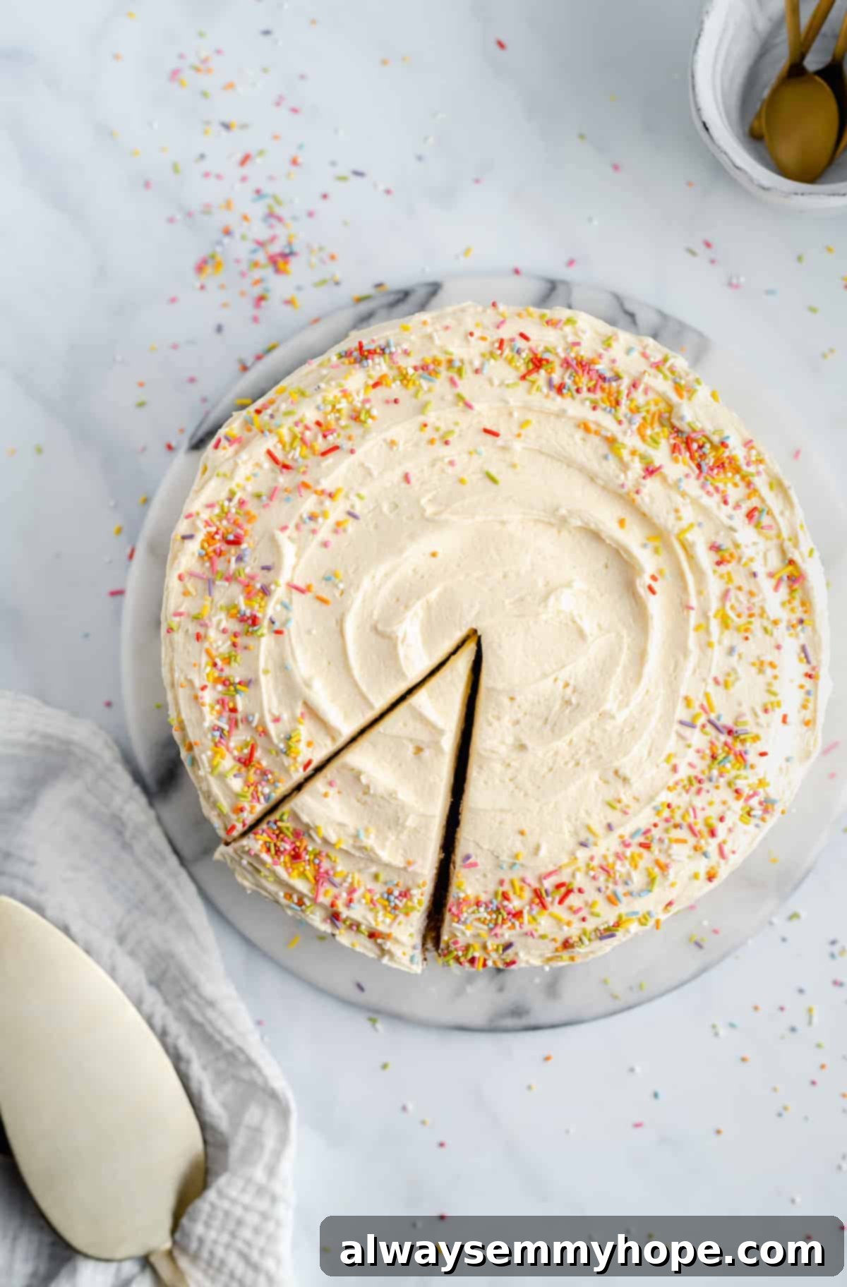 Indulge in a perfect slice of homemade vegan vanilla cake, topped with smooth, sweet buttercream. A delicious slice of vegan vanilla cake with creamy buttercream frosting, beautifully presented and ready to be enjoyed.