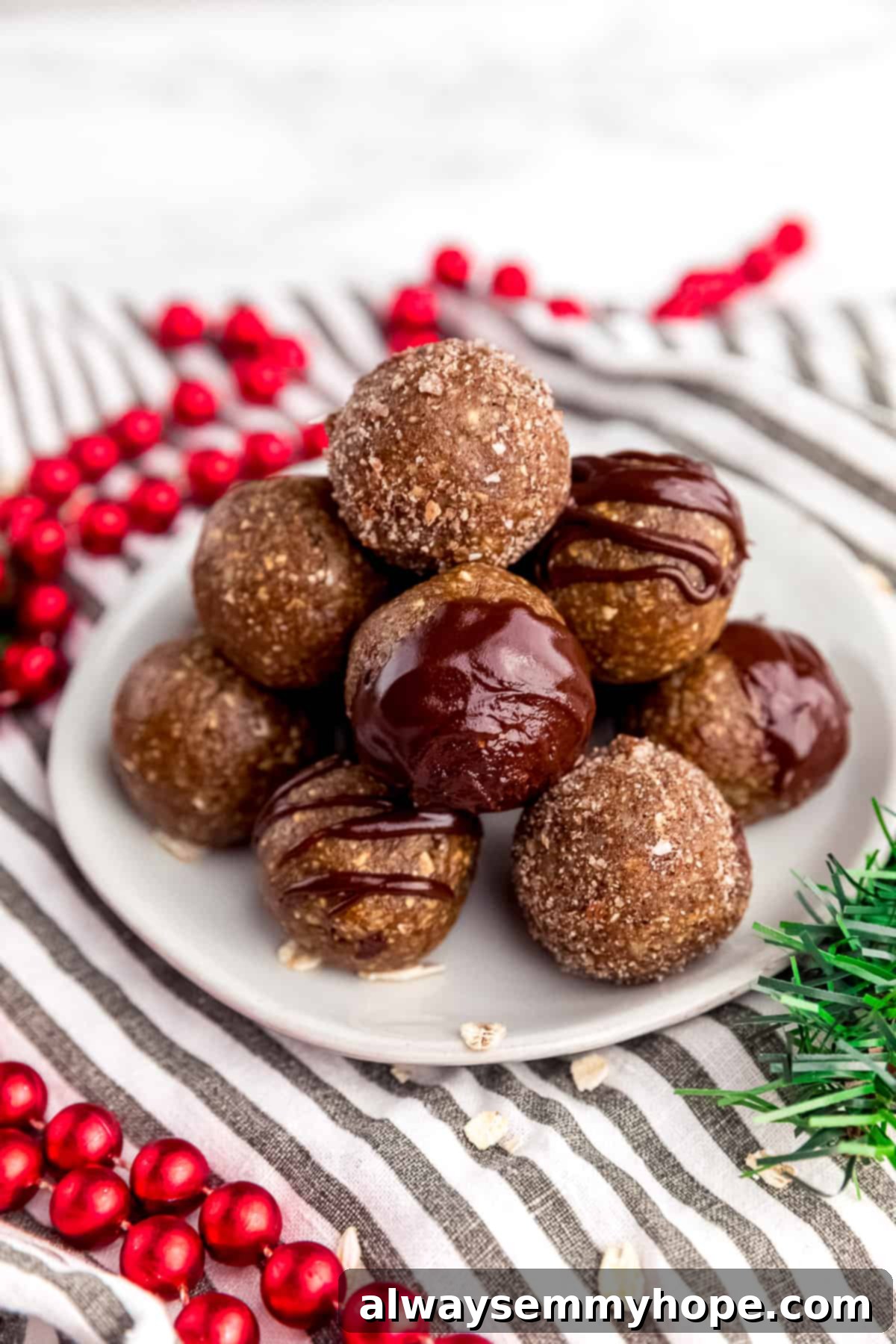 Festive Gingerbread Energy Bites 2 Gingerbread energy bites arranged in a festive pyramid stack on a plate with holiday decorations, highlighting their delicious and healthy appeal for a quick snack or breakfast.