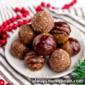 Festive Gingerbread Energy Bites 8 gingerbread energy bites in a pyramid stack on a plate with festive decor around