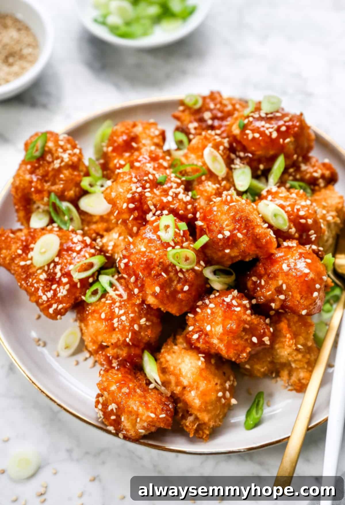 Crispy Sweet and Sour Cauliflower Wings 2 Crispy Sweet and Sour Cauliflower Wings piled high on a white plate, ready to be enjoyed with golden forks.