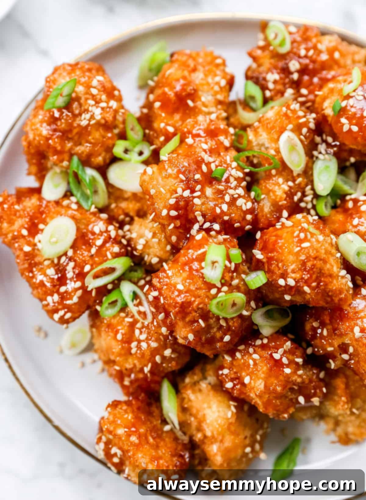 Crispy Sweet and Sour Cauliflower Wings 12 A tempting close-up shot of glossy sweet and sour cauliflower wings piled on a clean white plate.