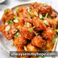 Crispy Sweet and Sour Cauliflower Wings 13 Sweet and Sour cauliflower wings piled on white plate beside gold forks