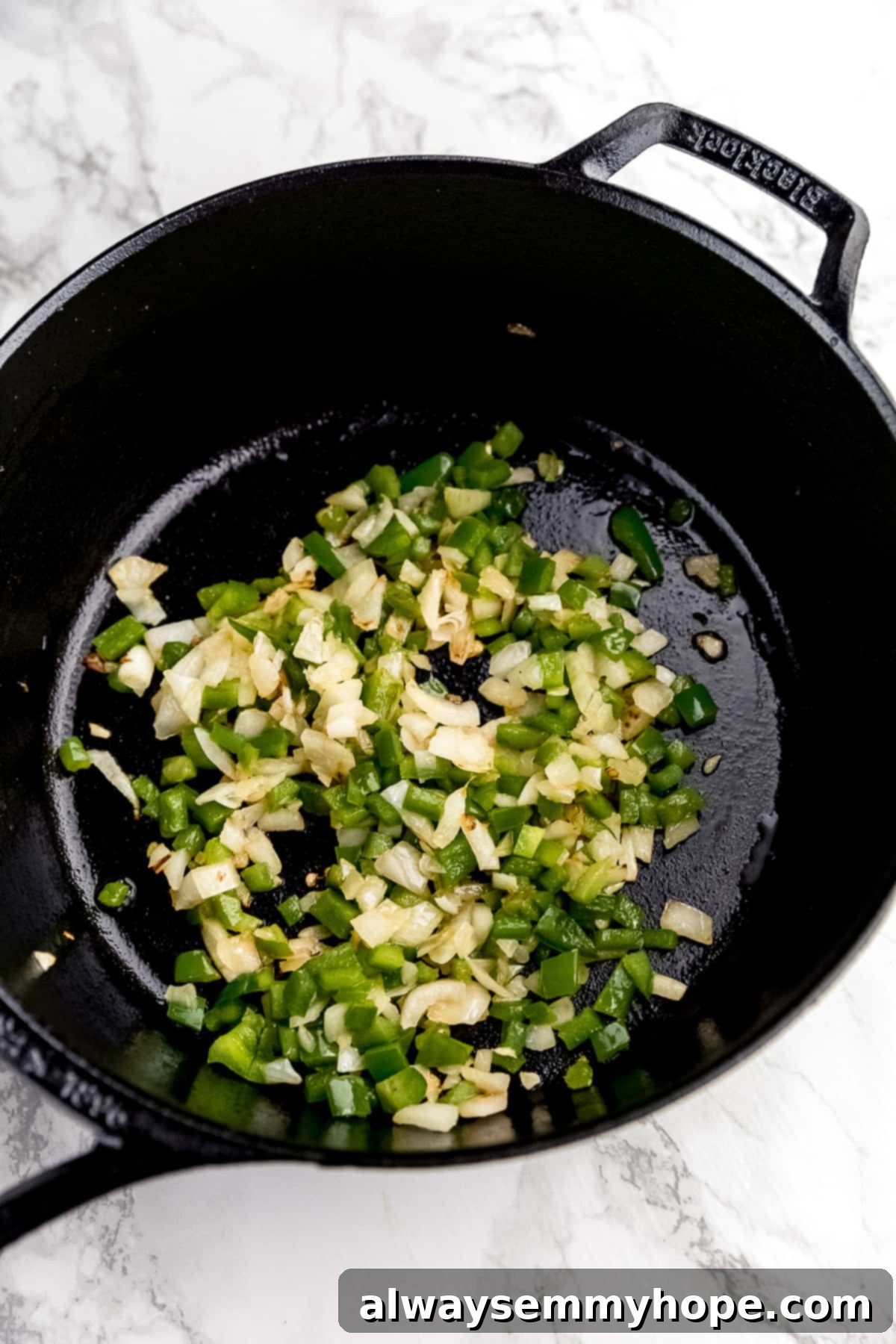 Wholesome Vegan Shakshuka 6 Diced onions and bell peppers gently sizzling in hot oil within a Blacklock cast iron skillet, becoming translucent and soft, forming the aromatic base of the shakshuka.