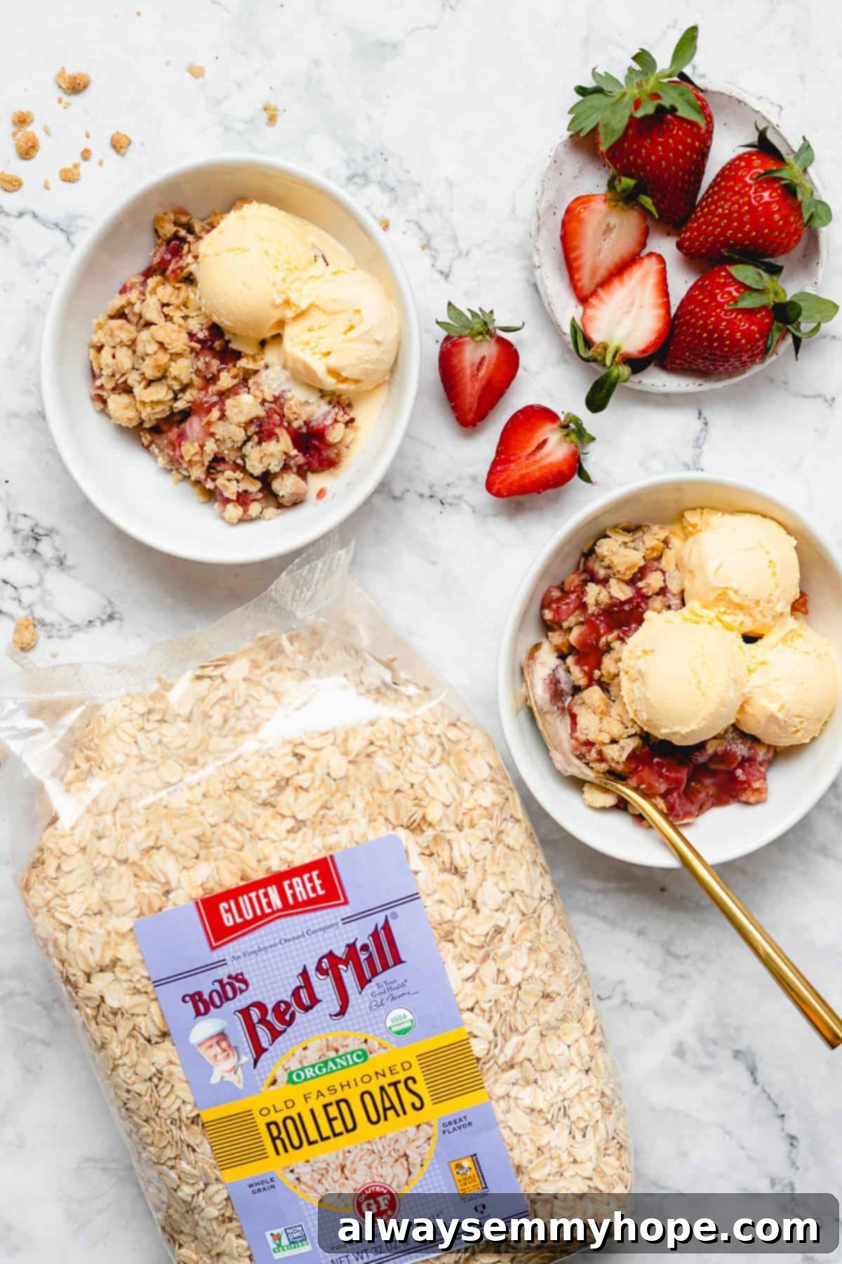 Enjoying Vegan Strawberry Crisp with Bob's Red Mill Oats and Fresh Berries Overhead view of two bowls of vegan strawberry crisp topped with ice cream, sitting beside a bag of Bob's Red Mill oats and fresh strawberries, showcasing the ingredients and finished dish.