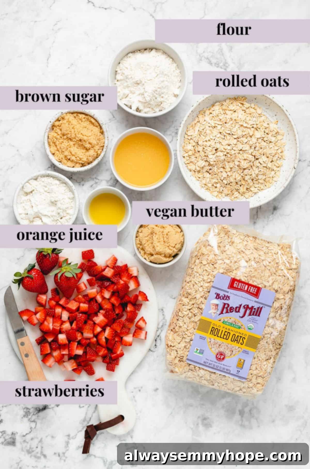 Essential Ingredients for a Delicious Vegan Strawberry Crisp A flat lay of all the fresh ingredients for strawberry crisp: fresh strawberries, brown sugar, flour, oats, vegan butter, orange juice, and sea salt, neatly arranged on a white surface.