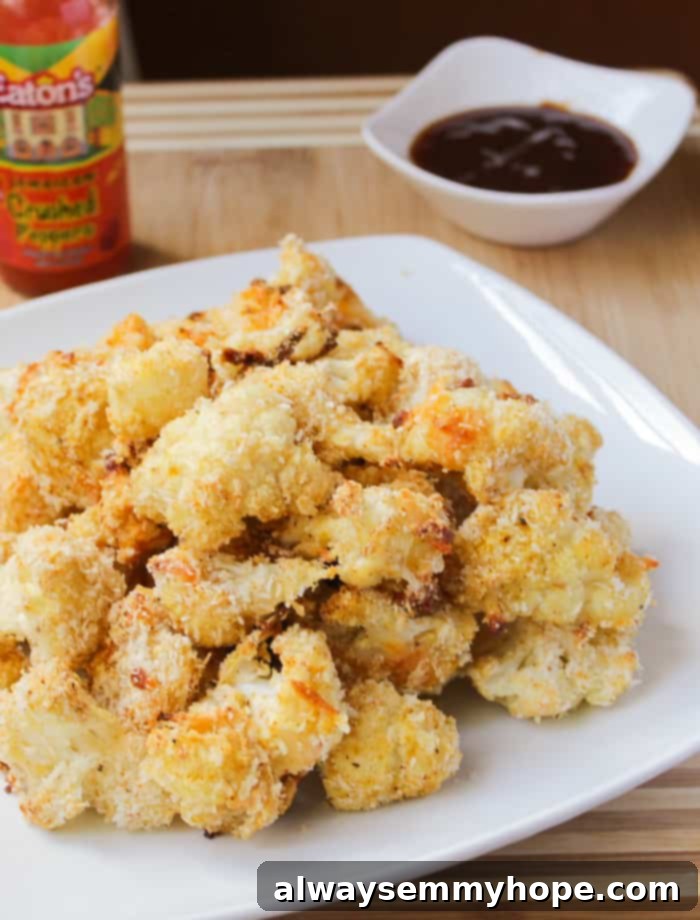 Cheesy Buffalo cauliflower wings with vegan cheddar and hot sauce, a savory appetizer.