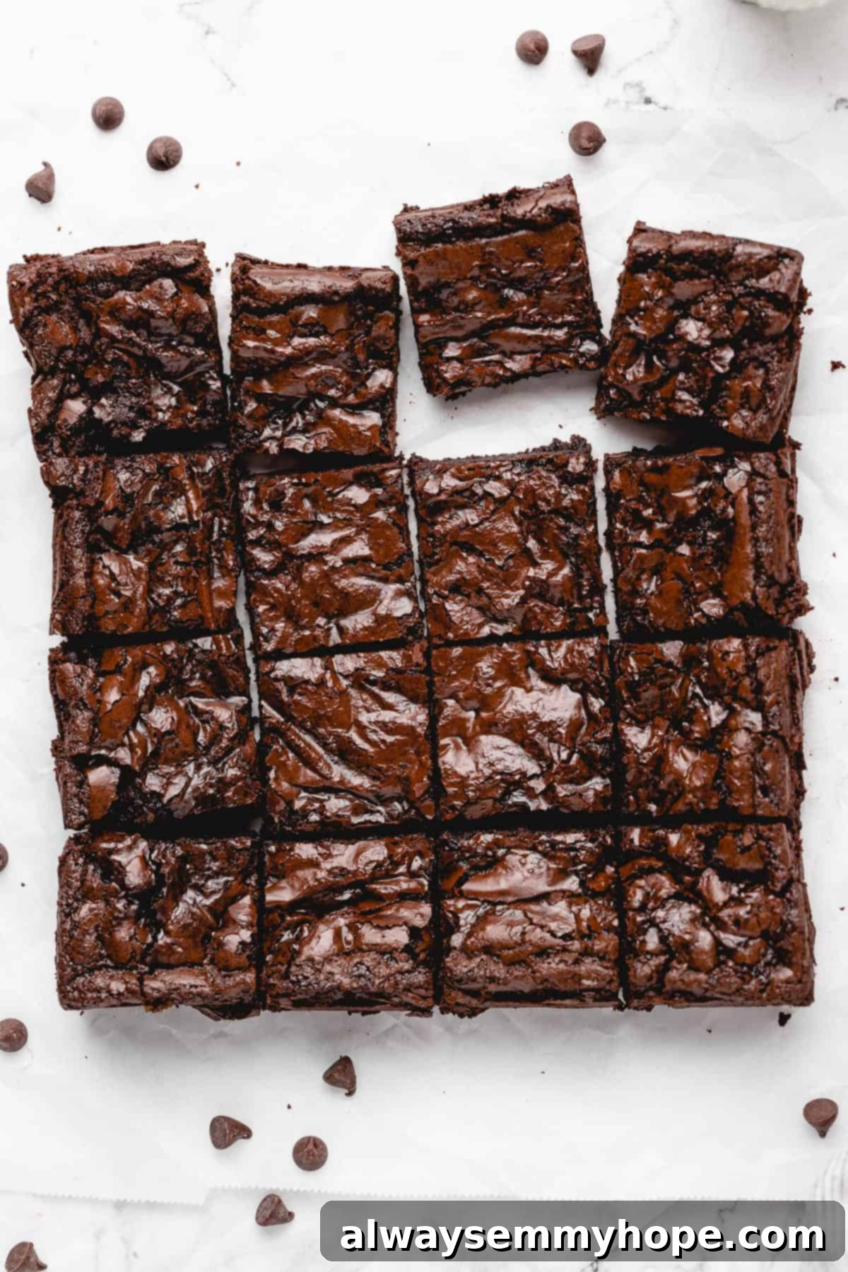 all 16 gluten-free vegan brownies sliced and a few pulled from the square, top down view