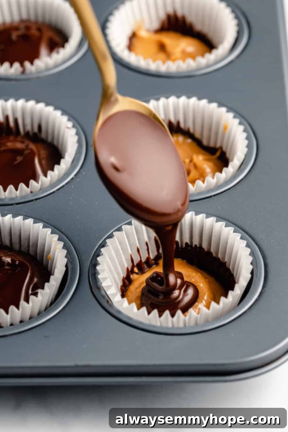 A Spoon Scooping the Top Layer of Chocolate Over the Peanut Butter