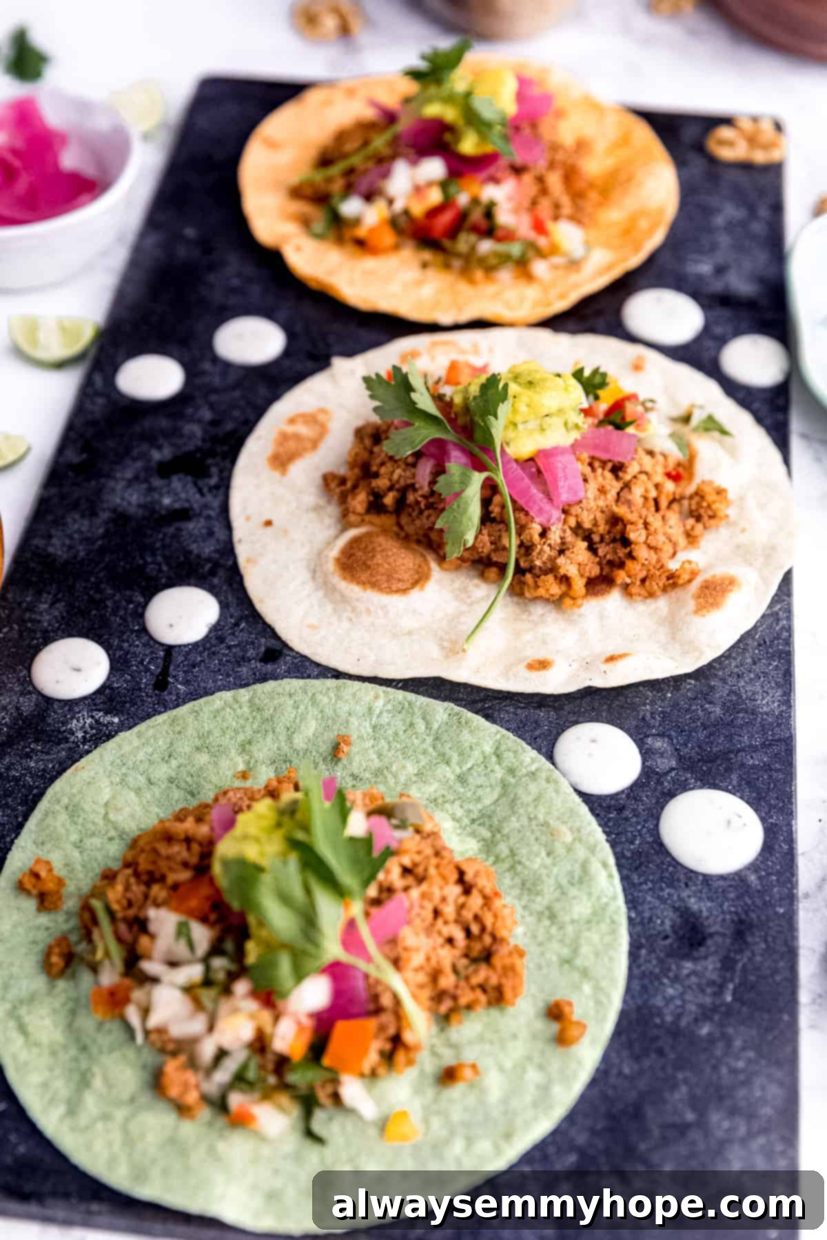 Irresistible Vegan Tacos 4 Assembled vegan tacos, garnished with fresh cilantro, creamy guacamole, and vibrant pickled onions.