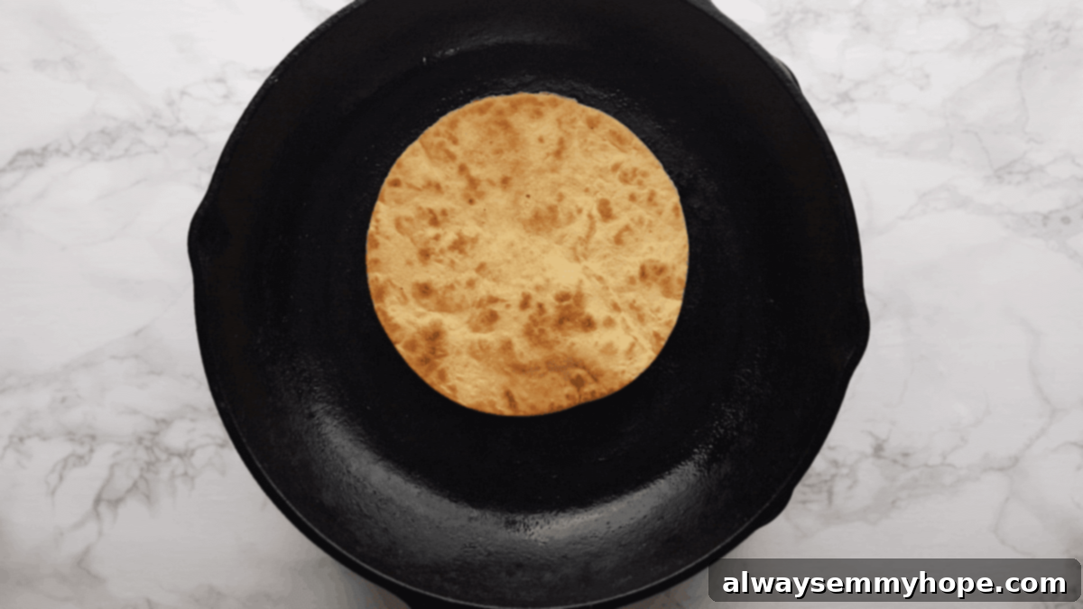Irresistible Vegan Tacos 9 A tortilla frying in a skillet, turning golden brown and slightly puffy.