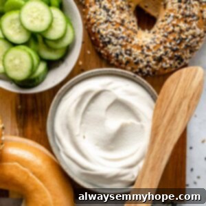 Plain cream cheese with bagels on a cutting board.