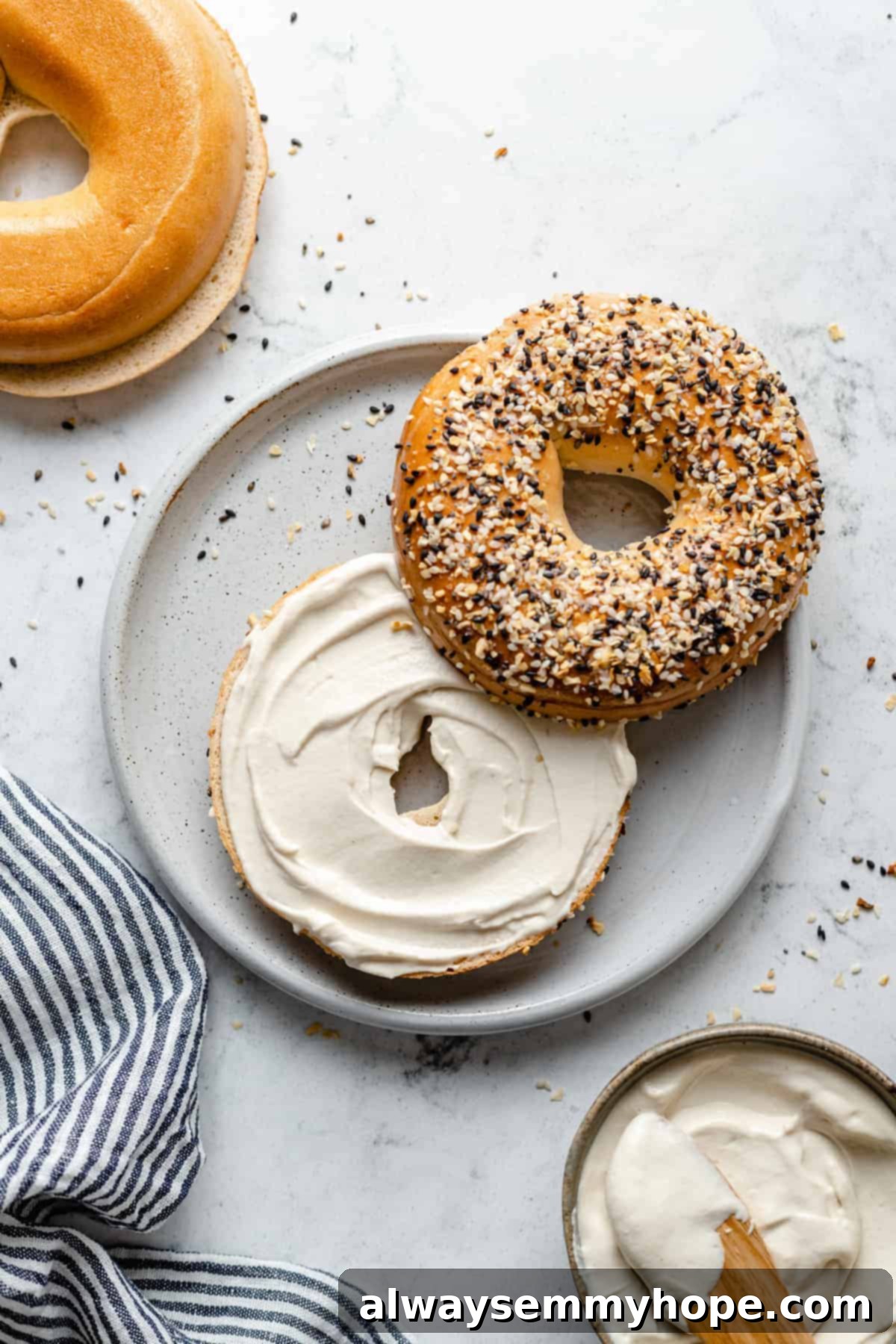 A perfectly toasted everything bagel generously spread with homemade vegan cream cheese, ready to eat.