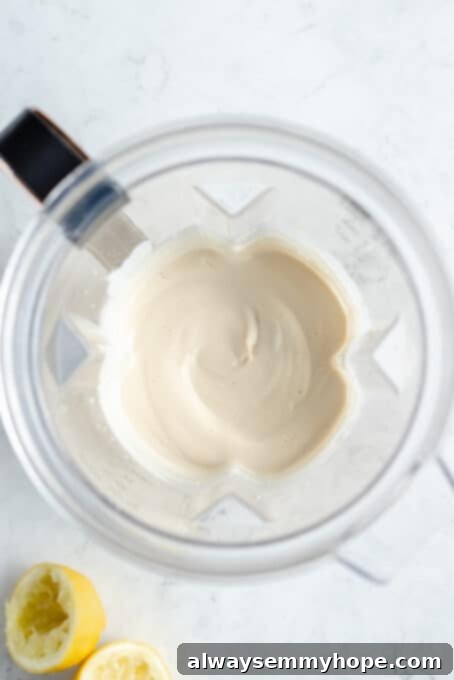 The smoothly blended mixture of vegan cream cheese in a blender, showing its creamy texture.