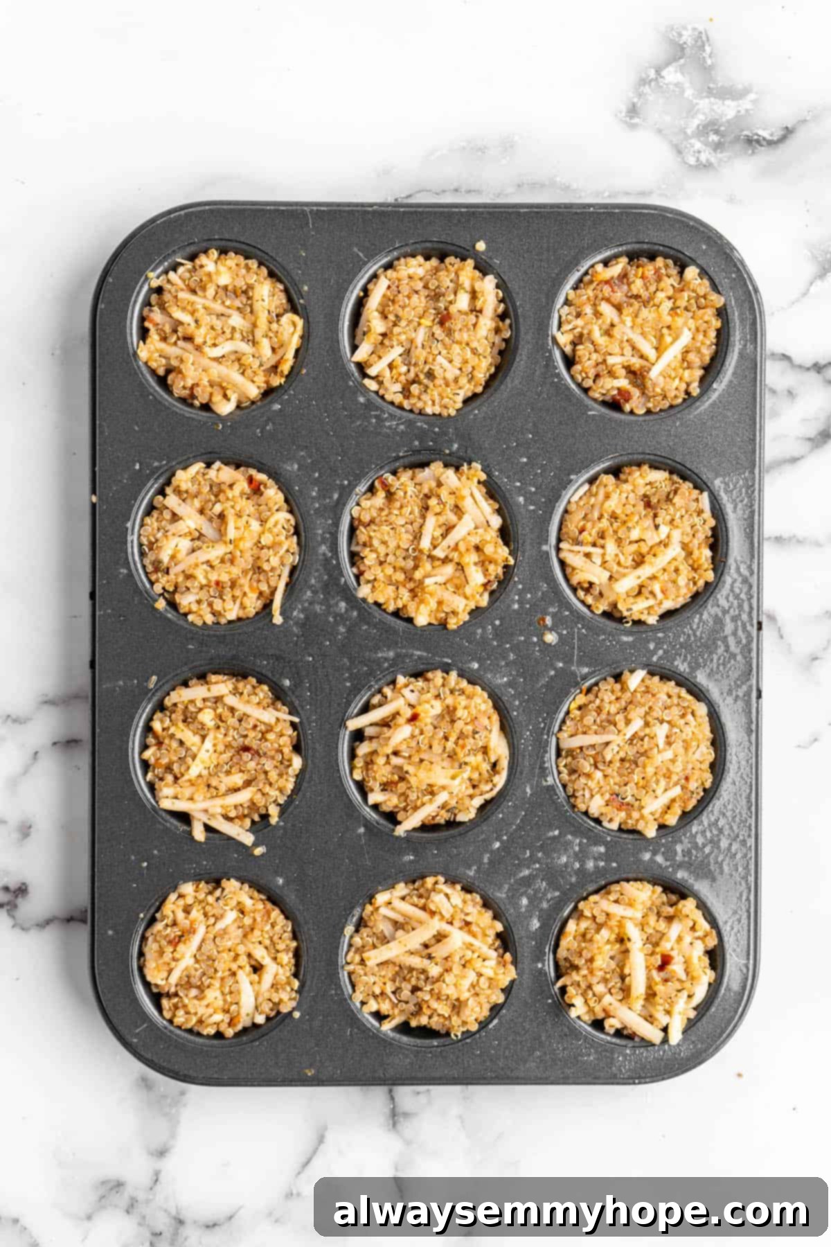 Quinoa pizza bites neatly packed into a mini muffin pan, awaiting baking. Prepared quinoa pizza bites neatly arranged in a mini muffin pan, ready for the oven