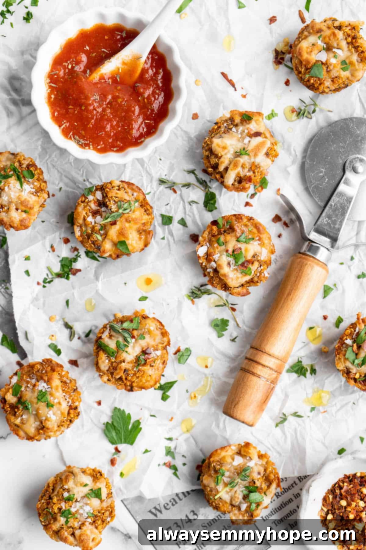 Warm Quinoa Pizza Bites, fresh from the oven, served with a side of marinara sauce. Freshly baked quinoa pizza bites arranged on parchment paper, with a small bowl of marinara sauce for dipping