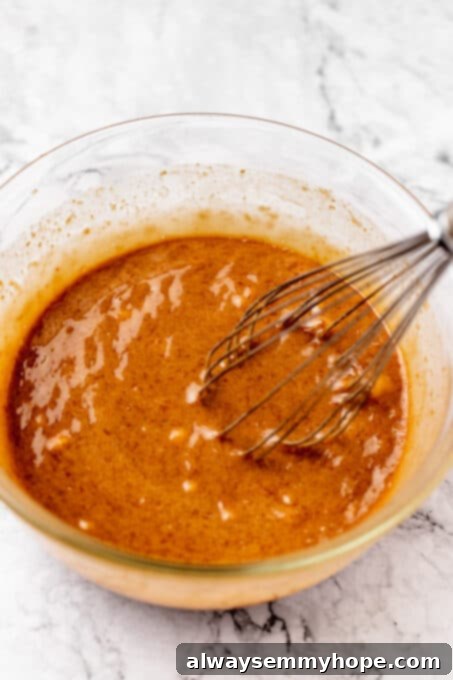 Fudgy Vegan Chocolate Banana Bread 6 Mashed bananas being added to the wet mixture of oil and flax eggs in a bowl.