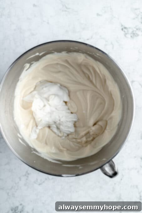 Vegan cream cheese and coconut cream being mixed together in a bowl, creating a smooth and rich base for the cheesecake.