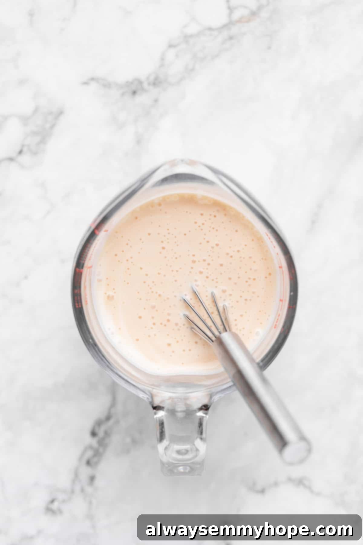 Fluffy Vegan Scones 4 A whisk in a glass bowl combining apple cider vinegar and vegan milk to create a buttermilk substitute