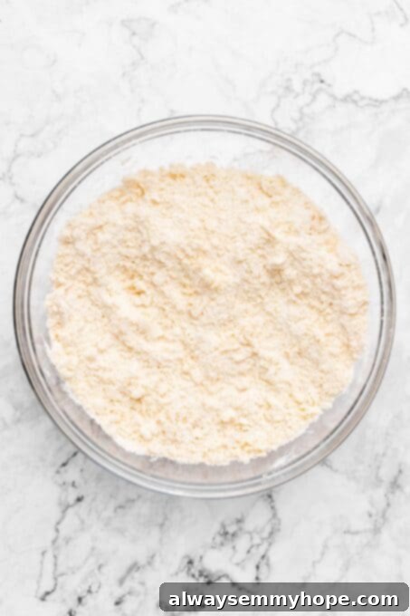 Fluffy Vegan Scones 6 Scone ingredients in a glass bowl with butter crumbles mixed in, resembling coarse sand