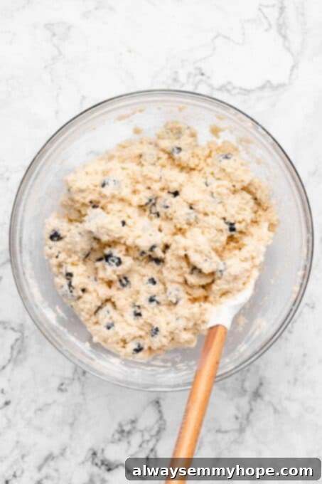 Fluffy Vegan Scones 7 A spatula mixing blueberries into shaggy scone dough in a glass bowl