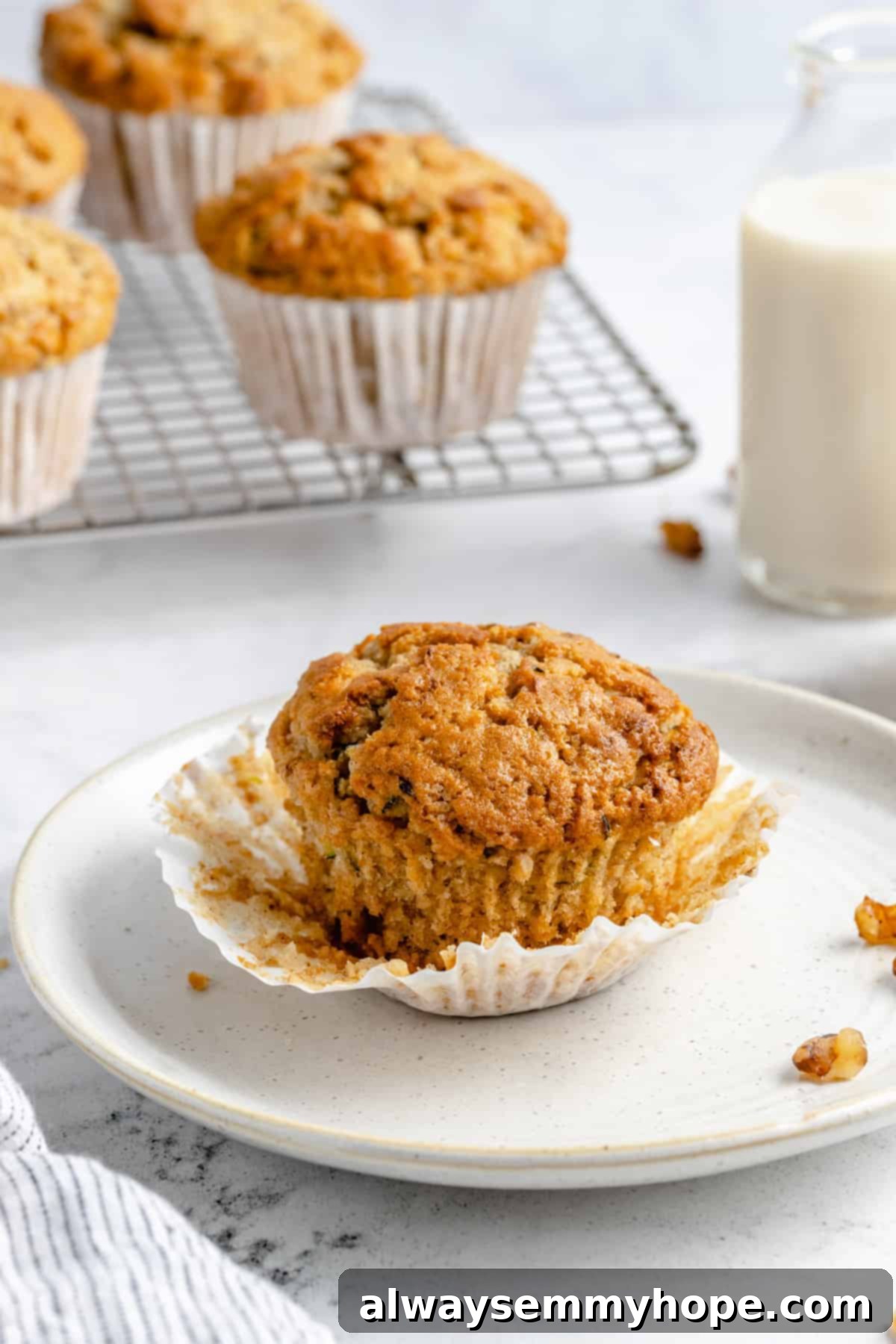 Garden-Fresh Vegan Zucchini Muffins 15 A perfectly baked vegan zucchini muffin, with its wrapper peeled back, highlighting its tender texture.