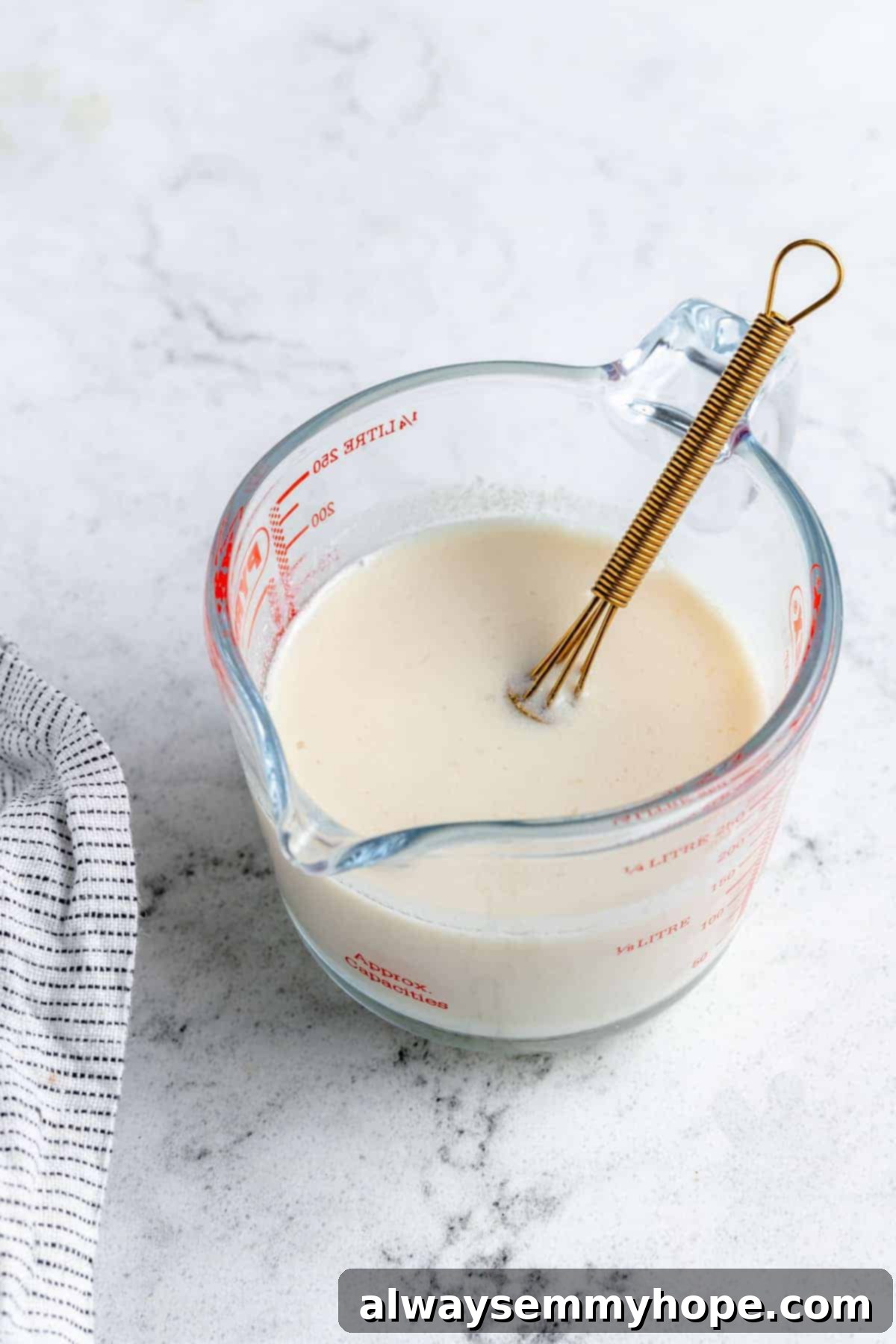 Ultimate Vegan Blueberry Muffins 6 A measuring cup filled with whisked vegan buttermilk, showing a slightly curdled texture.