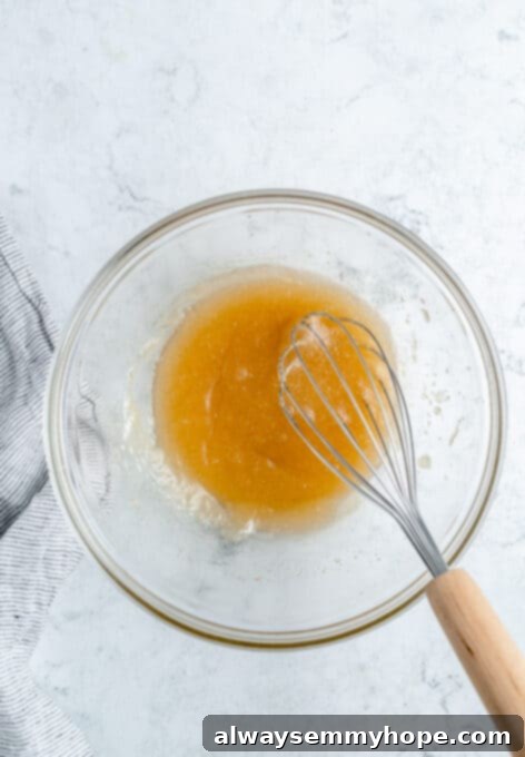 Ultimate Vegan Blueberry Muffins 7 A bowl containing oil, sugar, and vanilla extract, ready to be mixed for vegan blueberry muffins.