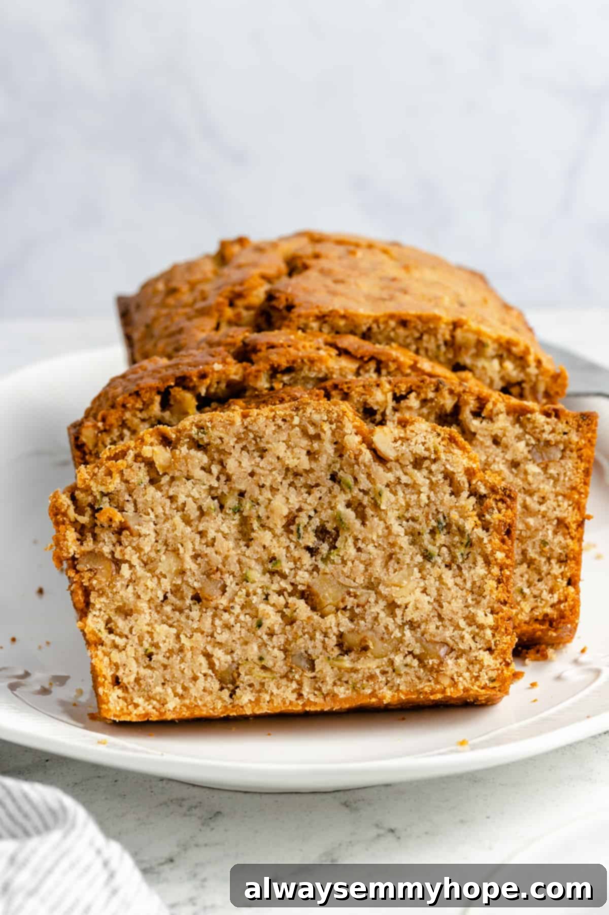 Slices of moist vegan zucchini bread, revealing a soft, tender crumb.